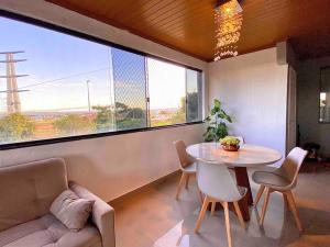 a living room with a table and chairs and a large window at 3 Quartos Com Vista Espetacular in Brasilia