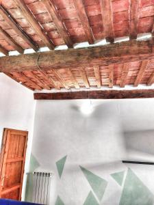 Pokój z drewnianym sufitem i białą ścianą w obiekcie Maremma Toscana House w mieście Prata