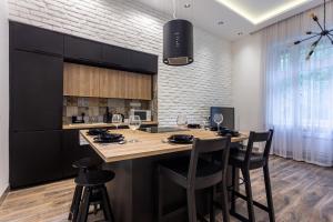 a kitchen with a large island with bar stools at Alder Bridge Apartment in Budapest