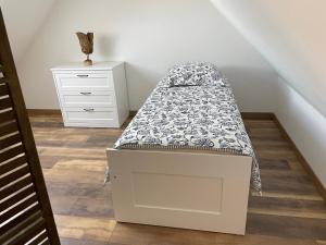 een klein wit bed in een kamer met een dressoir bij Logement pour 6 personnes 800 m des plages in Saint-Pabu