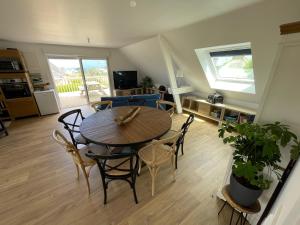 een woonkamer met een houten tafel en stoelen bij Logement pour 6 personnes 800 m des plages in Saint-Pabu