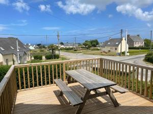 een houten picknicktafel op een terras bij Logement pour 6 personnes 800 m des plages in Saint-Pabu