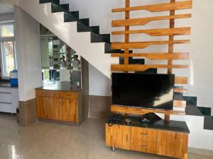 a living room with a flat screen tv and a staircase at Charming 2 Bedroom Rustic Villa with Garden in Lansdowne