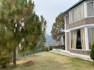 a house with a tree in front of it at Charming 2 Bedroom Rustic Villa with Garden in Lansdowne