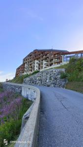 una strada di fronte a un edificio su una collina di Appartement pied des pistes - Samoëns 1600 a Samoëns