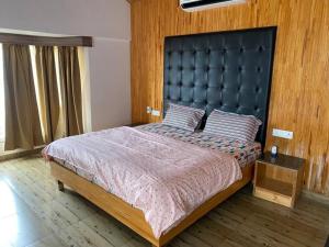 a bedroom with a large bed with a black headboard at Charming 2 Bedroom Rustic Villa with Garden in Lansdowne