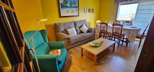 uma sala de estar com um sofá e uma mesa em A pie de playa em Vilariño