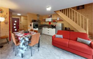 a kitchen and dining room with a table and a red couch at Nice Home In Mont-dore With Wifi in Le Mont-Dore