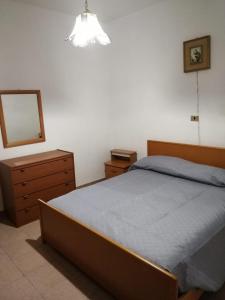 um quarto com uma cama, uma cómoda e um espelho em I Trecento em Padula