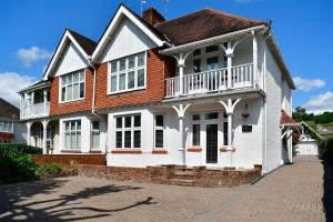 een wit huis met een balkon in een bakstenen straat bij Just Stay Wales - Highmead House, Swansea 