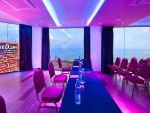 Habitación con una mesa larga, sillas e iluminación púrpura en The Ocean Colombo, en Colombo