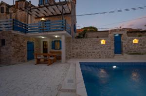 a villa with a swimming pool at night at House AnaDora with pool - Zlarin in Zlarin