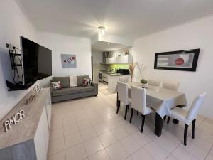 a dining room and living room with a table and chairs at Oasis del Sur in Puerto Madryn