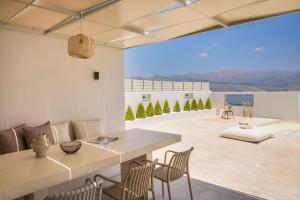 een woonkamer met een tafel en stoelen en uitzicht bij Villa Lavanta - Iris sunset villas in Lépedha