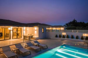 eine Villa mit Swimmingpool bei Nacht in der Unterkunft Villa Lavanta - Iris sunset villas in Lépedha