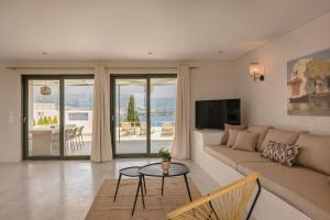 ein Wohnzimmer mit Sofa und Tisch in der Unterkunft Villa Lavanta - Iris sunset villas in Lépedha