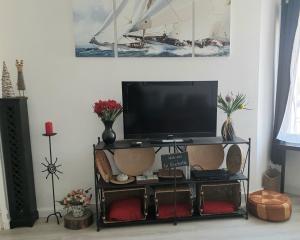 a tv sitting on a shelf in a living room at Maison sur le quai in La Rochelle