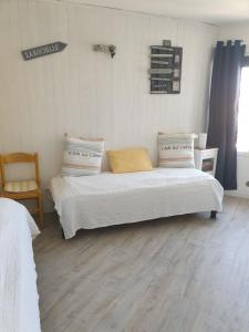 a bedroom with two beds and a chair in it at Maison sur le quai in La Rochelle