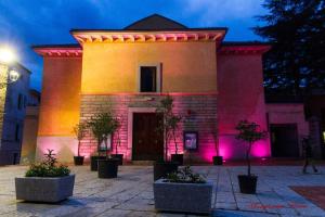 um edifício com luzes cor-de-rosa à frente em La casa di Noemi em Tempio Pausania