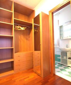um armário com prateleiras de madeira e um lavatório num quarto em La casa di Noemi em Tempio Pausania