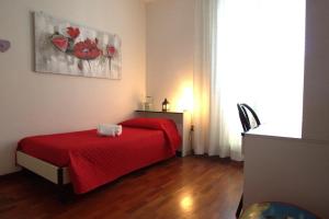 um quarto com uma cama vermelha e um cobertor vermelho em La casa di Noemi em Tempio Pausania