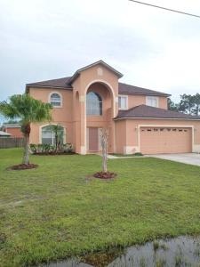 uma casa com uma palmeira em frente em Amore's luxurious 4 bedroom home. em Kissimmee