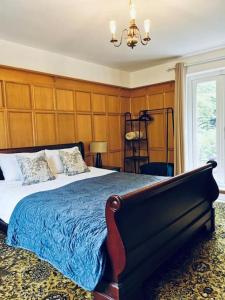 a bedroom with a large bed and a chandelier at Canalside Cottage in Barton under Needwood