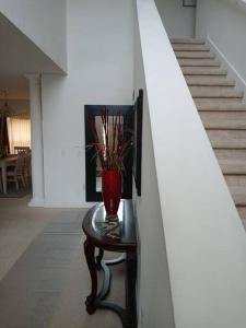un jarrón sentado en una mesa junto a una escalera en Amore's luxurious 4 bedroom home. en Kissimmee