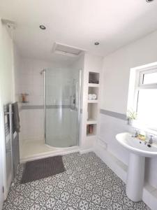 a white bathroom with a shower and a sink at Canalside Cottage in Barton under Needwood