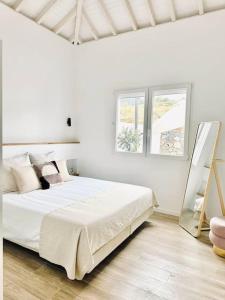 Breña AltaにあるLA GRAMA IV, comodidad y excelente ubicaciónの白いベッドルーム(ベッド1台、窓2つ付)