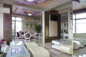 a living room with white furniture and a mirror at Kalina Family Hotel in Burgas