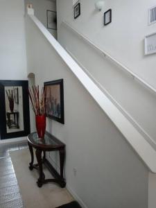 a stairway with a table with a vase on it at Amore's luxurious 4 bedroom home. in Kissimmee