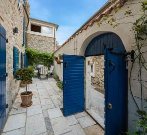 an archway with a blue door in an alley at Harbour Holiday Home "Vilmin Dvor" in Murter