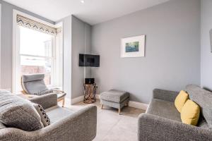 uma sala de estar com duas cadeiras e uma televisão em Swn-y-Don em Aldeburgh