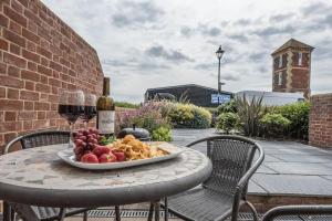 uma mesa com um prato de comida e um copo de vinho em Swn-y-Don em Aldeburgh