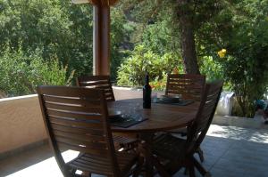 a wooden table with chairs and a bottle of wine at The Garden House, Sitia in Sitia