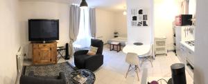 sala de estar con TV, sofá y sillas en La Chantrerie, en Cahors