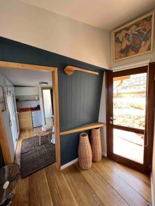 ein Wohnzimmer mit einer Tür und ein Zimmer mit Holzböden in der Unterkunft Corto in Lefkada Town