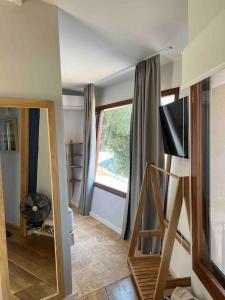 ein Wohnzimmer mit einem TV und einem Fenster in der Unterkunft Corto in Lefkada Town