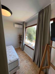 Una habitación con ventana y una cama en una habitación en Corto, en Lefkada