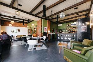 a restaurant with green furniture and a table and chairs at Hermannuse Maja in Haapsalu