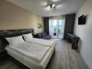 普里莫爾斯科的住宿－Hotel Lotus，一间卧室配有一张大床和一张沙发