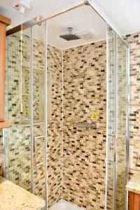 een douche met glazen deuren in de badkamer bij Just Stay Wales - Highmead House, Swansea 
