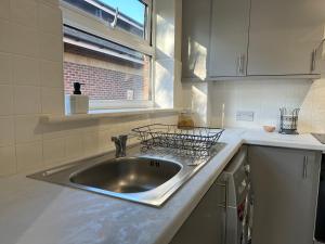 um balcão de cozinha com um lavatório e uma janela em Sunderland City Centre Modern 2 Bed Apartment em Sunderland