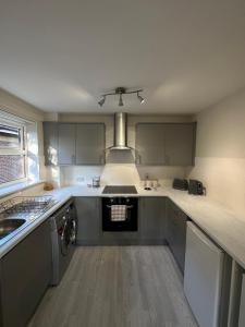 uma cozinha com um lavatório e um fogão forno superior em Sunderland City Centre Modern 2 Bed Apartment em Sunderland