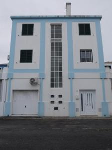 ein blau-weißes Gebäude mit zwei Garagen in der Unterkunft Forte do Ilhéu de Vila Franca in Vila Franca do Campo