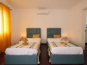 dwa łóżka w pokoju z dwoma świecami w obiekcie Forte do Ilhéu de Vila Franca w mieście Vila Franca do Campo