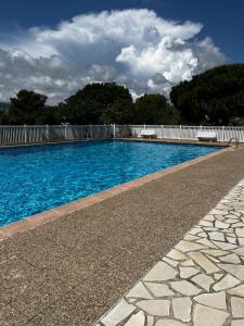 une piscine d'eau bleue et une clôture blanche dans l'établissement LA BOHÊME by K6 Conciergerie Villas, à Cassis