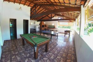 a living room with a pool table in a house at Chácara condomínio perto de SP in Ibiúna