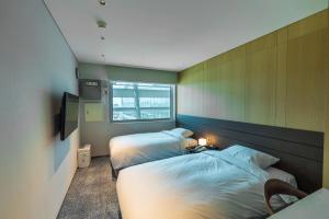 a bedroom with two beds and a window at Incheon Airport Transit Hotel Terminal 1 in Incheon